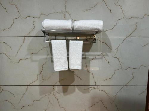 a bathroom with two towels on a marble wall at STARLIT Hotel, Ajmer in Madār
