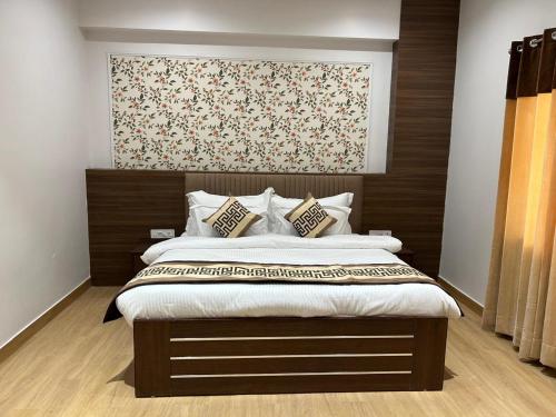 a bedroom with a large bed with a wooden headboard at STARLIT Hotel, Ajmer in Madār