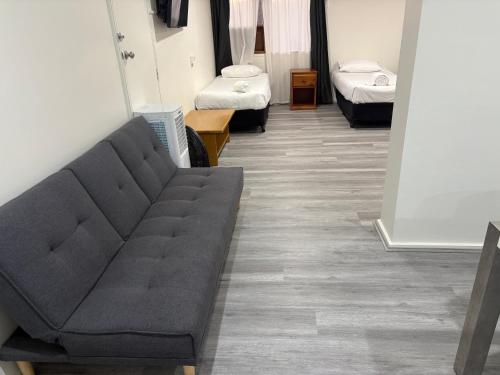 a living room with a couch and two beds at Nowra Motor Inn in Nowra