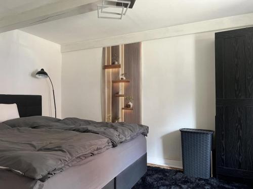 a bedroom with a bed and a lamp on the wall at NEU! Dat Lütt Hüs in Tönning