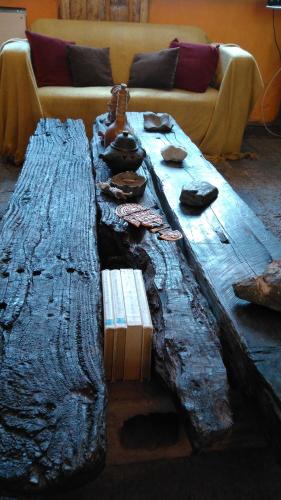 a large wooden table with a couch in a living room at Portezuelo del Viento - Hostel de Montaña in Las Cuevas