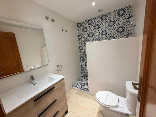a bathroom with a sink and a toilet and a mirror at Urbanización Torremar Natura in Vera