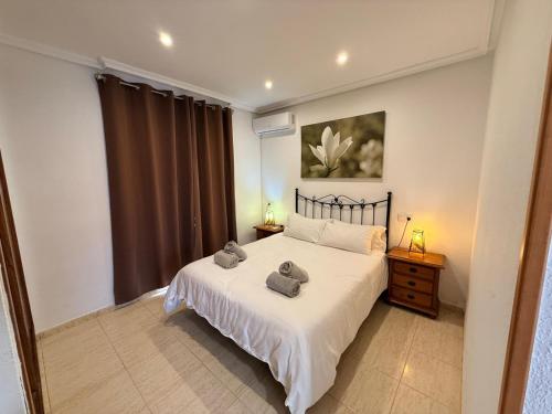 a bedroom with a bed with two towels on it at Urbanización Torremar Natura in Vera