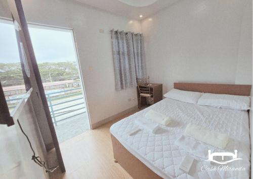 a bedroom with a bed and a large window at Casa-Miranda Homestay in Daet