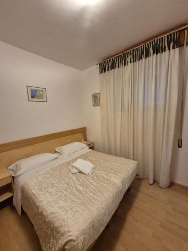 a bedroom with two beds and a window at Grazia Hotel in Sperlonga