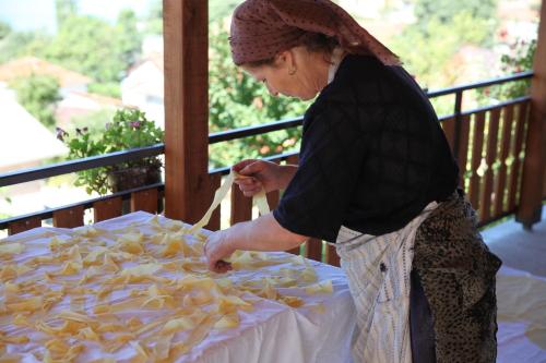 a woman standing next to a table of food at Risto's Guest House in Ohrid