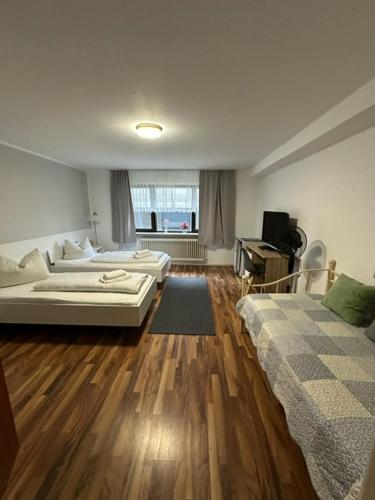two beds in a room with wooden floors at Römerhof in Bad Bellingen