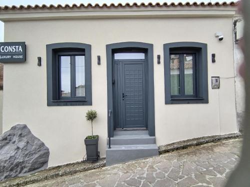 a house with a blue door and two windows at CONSTA Luxury House in Mantamádos