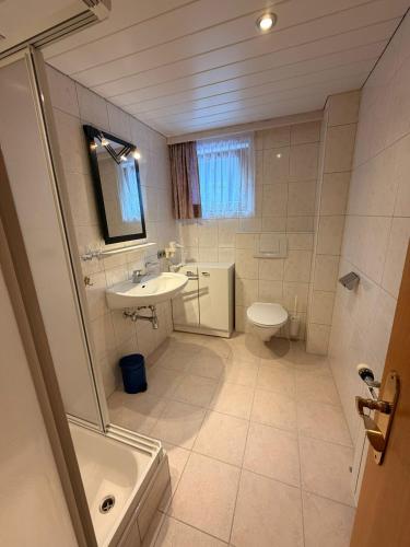a white bathroom with a sink and a toilet at Haus Brunelle in Damuls