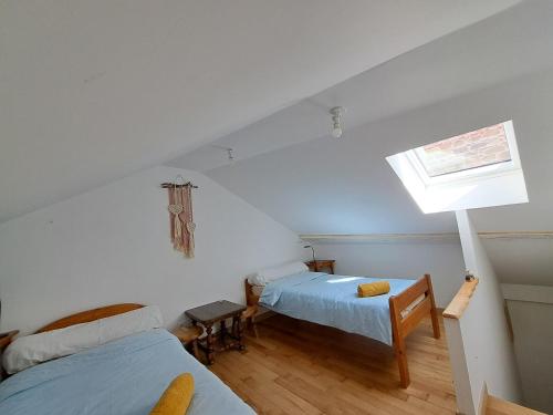 a attic room with two beds and a window at L'Isba in Saint-Appolinaire