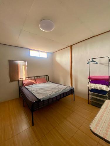 a bedroom with a bed in the corner of a room at Teak Soul Home in Ban Na Toeng Nai