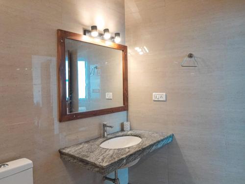 a bathroom with a sink and a mirror and a toilet at The Three Oaks Boutique Hotel in Mussoorie