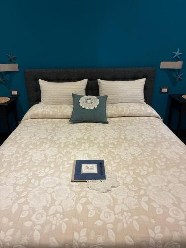 a bed with a book on top of it at Affittacamere La Risacca in La Spezia