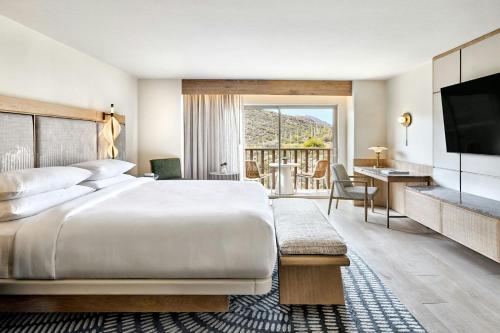 a bedroom with a bed and a desk and a television at JW Marriott Tucson Starr Pass Resort in Tucson