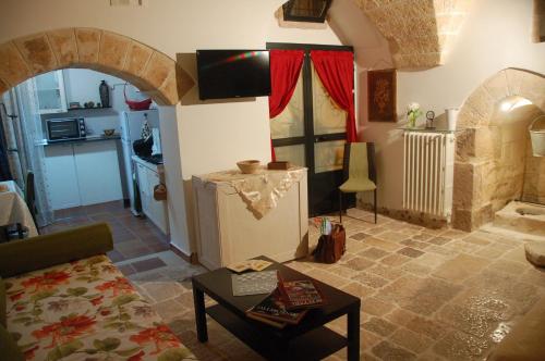 ein Wohnzimmer mit einem Sofa und einem TV in einem Haus in der Unterkunft Antro delle Muse in Altamura