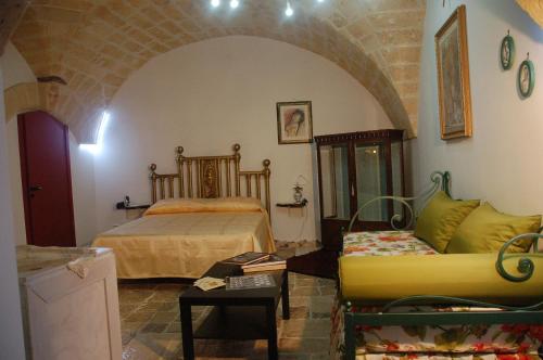ein Schlafzimmer mit einem Bett und einem Sofa in der Unterkunft Antro delle Muse in Altamura