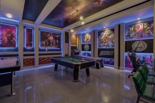 a game room with a pool table and posters on the walls at 9 BD 6.5 BA Solara Resort 9028 FK in Orlando