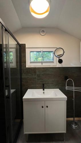 a bathroom with a white sink and a window at Planeta Glamping in Zalesie Górne