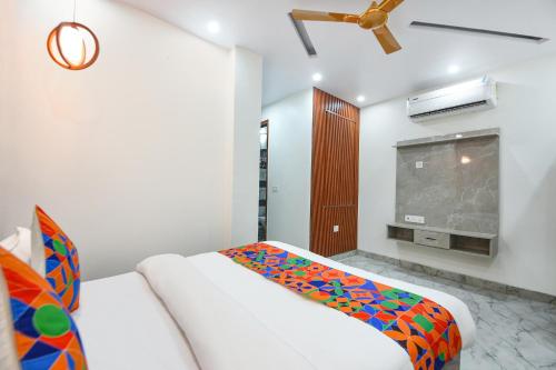 a bedroom with a white couch and a tv at Via The Arrow in New Delhi