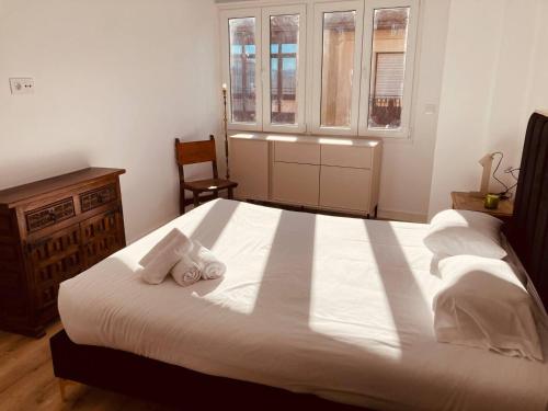 a bedroom with a large white bed with two towels at Fuentes 8 in Soria