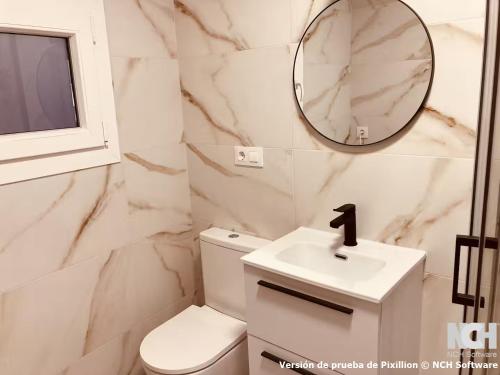 a bathroom with a toilet and a sink and a mirror at Fuentes 8 in Soria
