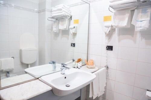 a white bathroom with a sink and a mirror at Balletti Palace Hotel in Viterbo