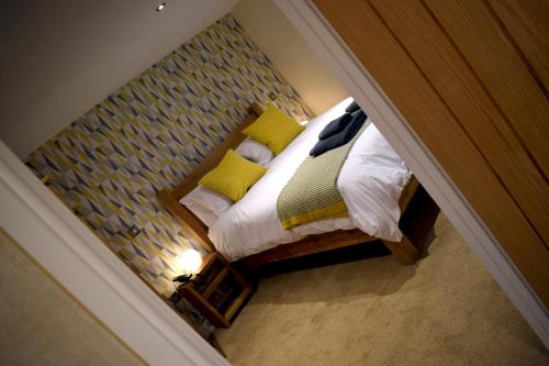 a bedroom with a bed with yellow pillows at The Horse & Jockey in Alfreton