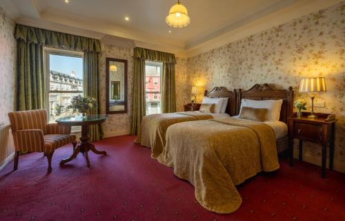 a hotel room with two beds and a window at Arbutus Hotel in Killarney