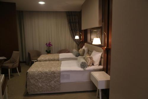 a hotel room with a bed and tables and chairs at Vivaldi Park Hotel in Ankara