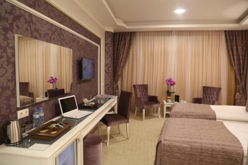 a hotel room with a bed and a desk with a laptop at Vivaldi Park Hotel in Ankara