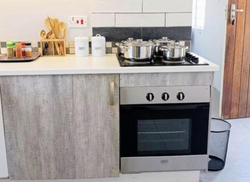 a kitchen with a stove with pots and pans at DeltaGateway selfcatering in Maun Airport