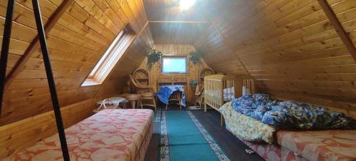 a room with two beds in a wooden cabin at Zlatý Žabák in Suchý