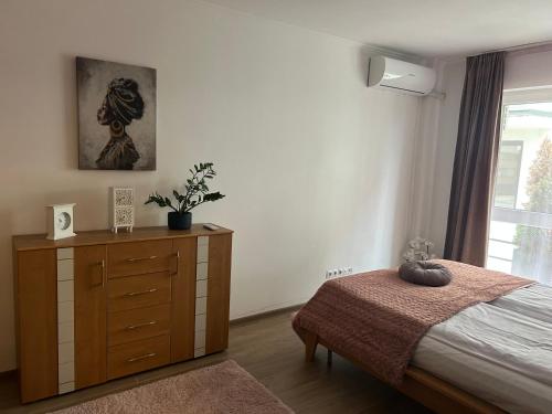 a bedroom with a bed and a dresser and a window at Bella in Târgu-Mureş