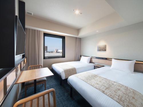 a hotel room with two beds and a flat screen tv at REF Kansai Airport by VESSEL HOTELS in Izumi-Sano