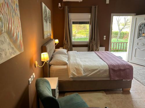 a bedroom with a bed and a window and a chair at Akrotiri studios in Samothraki