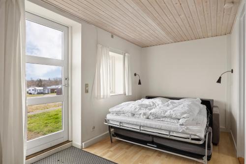a bedroom with a bed in a room with a window at Sorø Camping & Cottages in Sorø