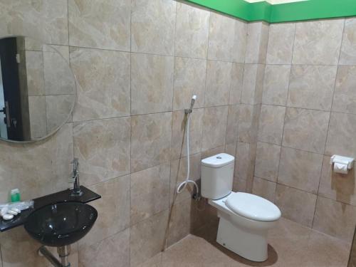 a bathroom with a toilet and a sink at green hotel 2 ciamis in Ciamis
