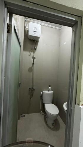 a small bathroom with a toilet and a sink at Hotel SIDAPORE in Lamobuang