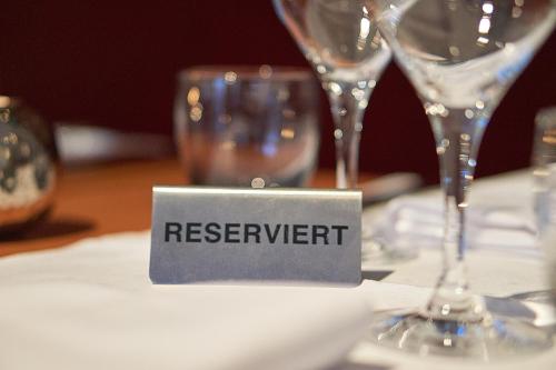 a reserved sign sitting on a table with wine glasses at relexa hotel Stuttgarter Hof in Berlin