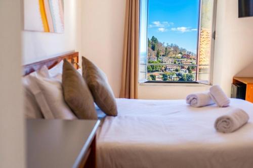 a bedroom with two beds and a window at Locanda Milano 1873 in Brunate