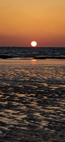 a sunset on a beach with the ocean at Awas Beach Stays in Avas