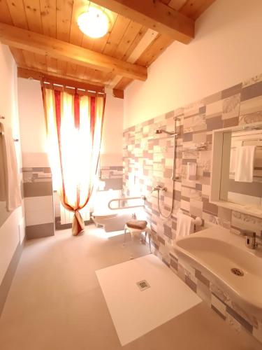 ein Badezimmer mit zwei Waschbecken und einem großen Fenster in der Unterkunft Riama in Torralba