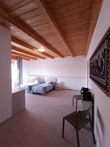 ein Zimmer mit zwei Betten und einem Stuhl in der Unterkunft Riama in Torralba