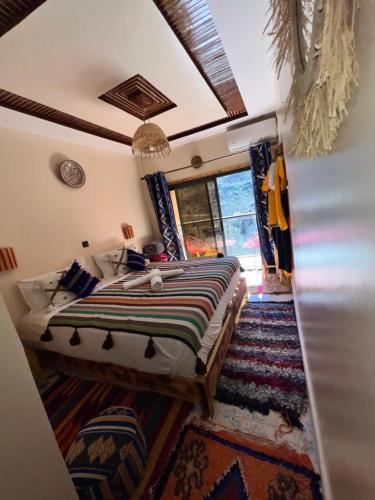 a bedroom with a bed and a large window at Atlas Green Lodge in Imlil