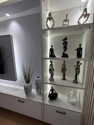 a white shelf with figurines and vases on it at Abla's sweet home in Tirana