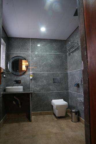 a bathroom with a toilet and a sink and a mirror at Green Inn in Pahalgām