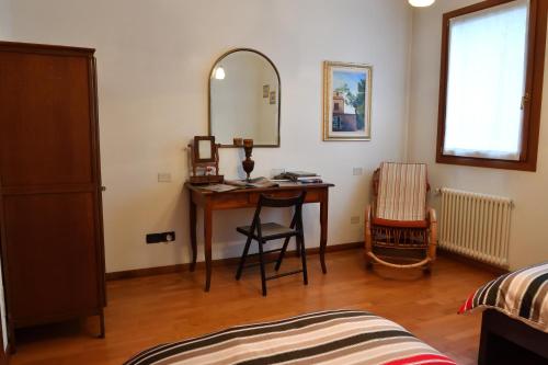 a bedroom with a desk with a mirror and a chair at Agriturismo Memento in Follina