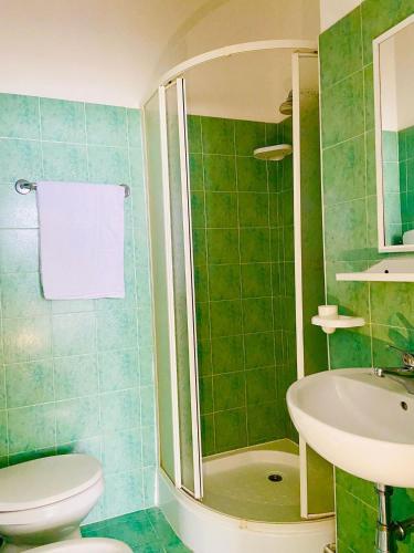a green bathroom with a toilet and a sink at Hotel Europa in Gabicce Mare