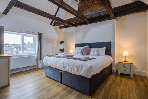 a bedroom with a large bed and a large window at Modern 1 Bed - Beams - Parking in Stamford