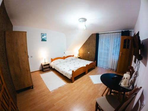 a bedroom with a bed and a table with a television at Willa Anna Maria in Wysowa-Zdrój